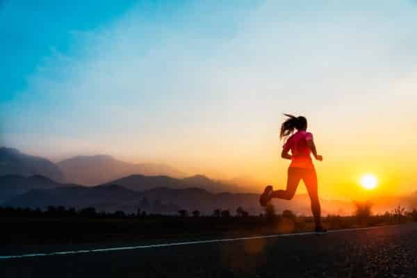 Young woman enjoys running outside with beautiful summer evening